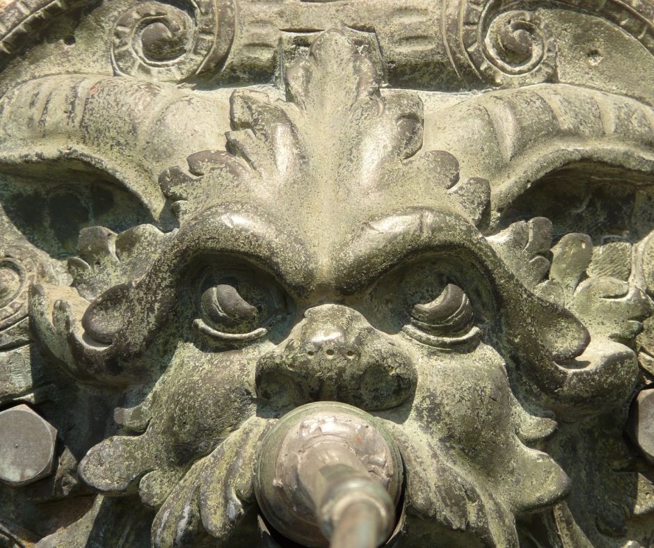 Image of a stone gargoyle that looks a little like a dog and a little like a person
