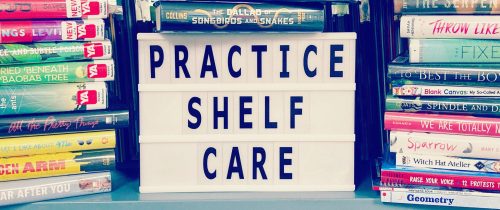 Piles of books surrounding a sign that reads "Practice Shelf Care"